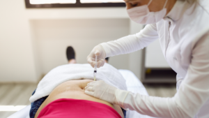 Woman administering GLP-1 receptor agonist injection into abdominal area for weight loss.